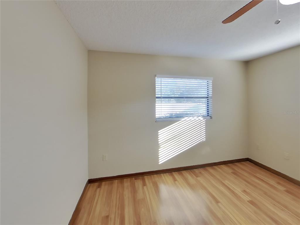 Undisclosed Address Spring Hill, FL 34608 - Photo 9 of 16 a view of empty room with wooden floor and fan