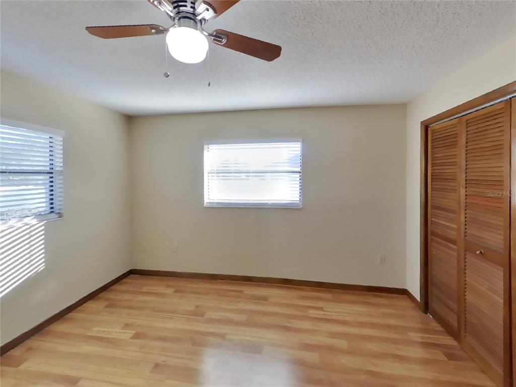 Undisclosed Address Spring Hill, FL 34608 - Photo 10 of 16 an empty room with wooden floor and windows