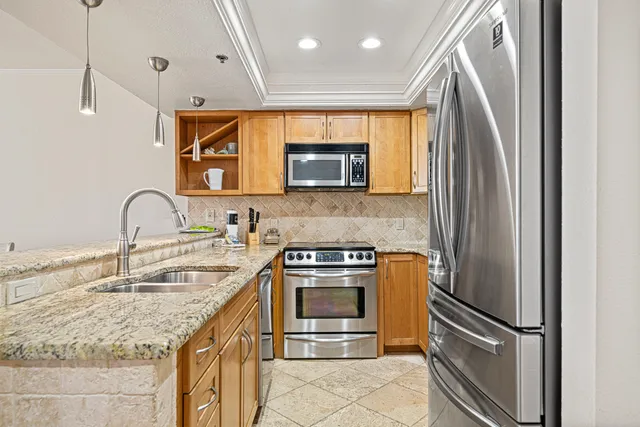 a kitchen with stainless steel appliances granite countertop a sink stove and refrigerator