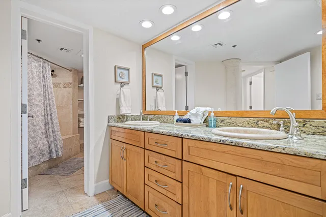 a bathroom with double vanity sinks and a shower