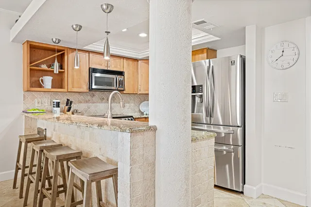 a kitchen with stainless steel appliances granite countertop a refrigerator and a stove top oven