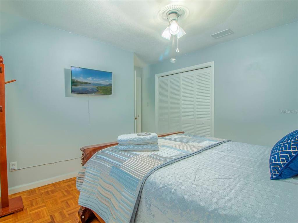 Undisclosed Address Orlando, FL 32812 - Photo 19 of 26 a bedroom with a large bed and a chandelier