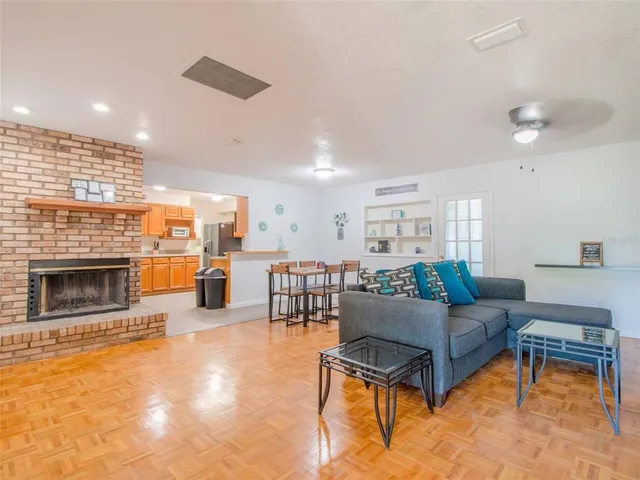 a living room with furniture a fireplace and a kitchen view