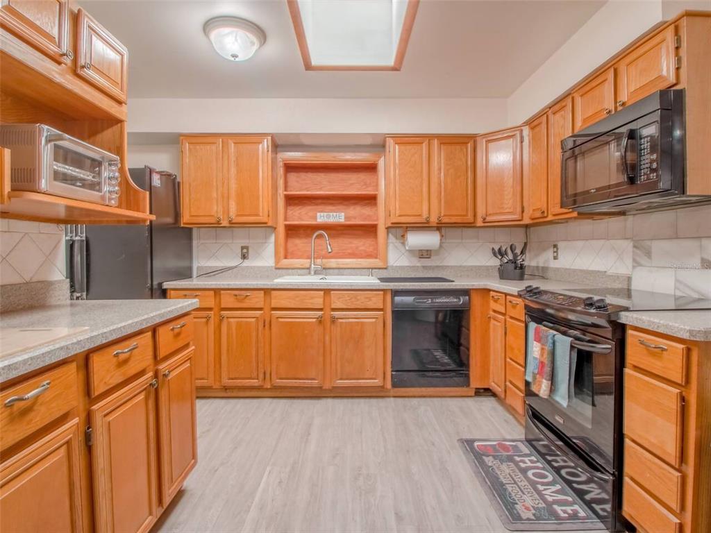 Undisclosed Address Orlando, FL 32812 - Photo 9 of 26 a kitchen with stainless steel appliances granite countertop a stove a sink and a microwave