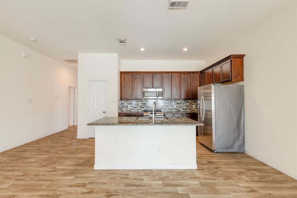 14247 Greenhaw Lane Dallas, TX 75253 - Photo 28 of 39 a kitchen with stainless steel appliances granite countertop a refrigerator and a stove