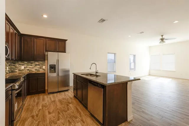 a kitchen with stainless steel appliances granite countertop a sink stove and refrigerator
