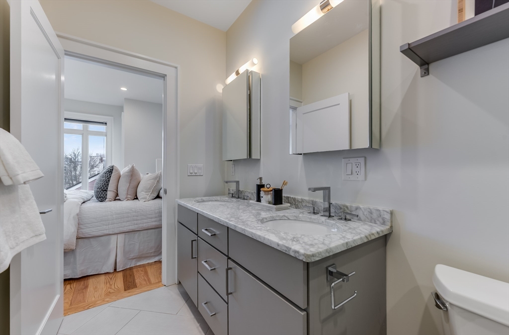17 Vinton Street, Unit 3 Boston, MA 02127 - Photo 15 of 21 a bathroom with a granite countertop sink a toilet and mirror