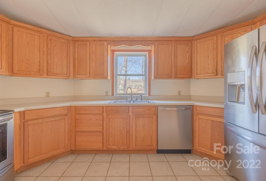 890 Hyder Mountain Road Clyde, NC 28721 - Photo 6 of 24 a kitchen with granite countertop a sink window and cabinets