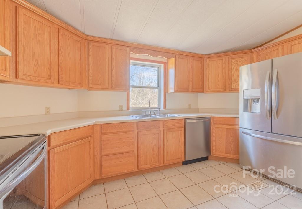 890 Hyder Mountain Road Clyde, NC 28721 - Photo 7 of 24 a kitchen with granite countertop white cabinets and refrigerator