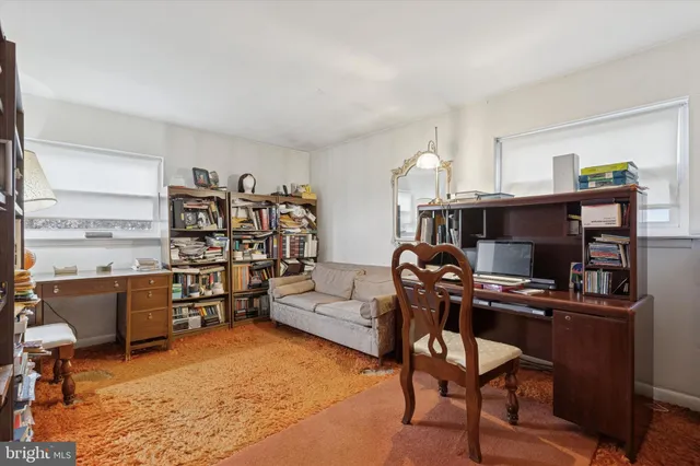 a view of a workspace with furniture and a window