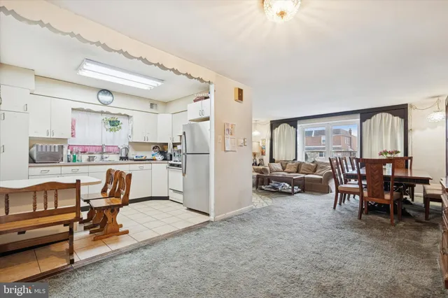 a living room with furniture and a dining table with kitchen view