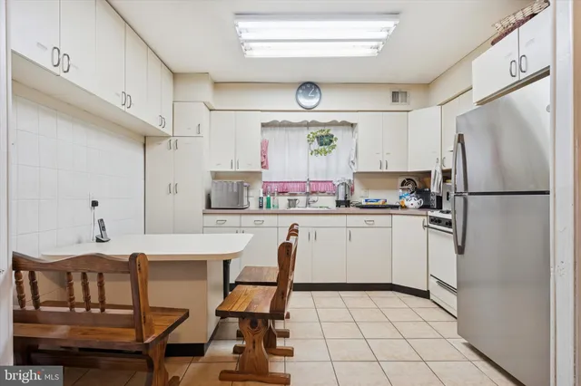 a kitchen with a refrigerator a stove a sink and cabinets