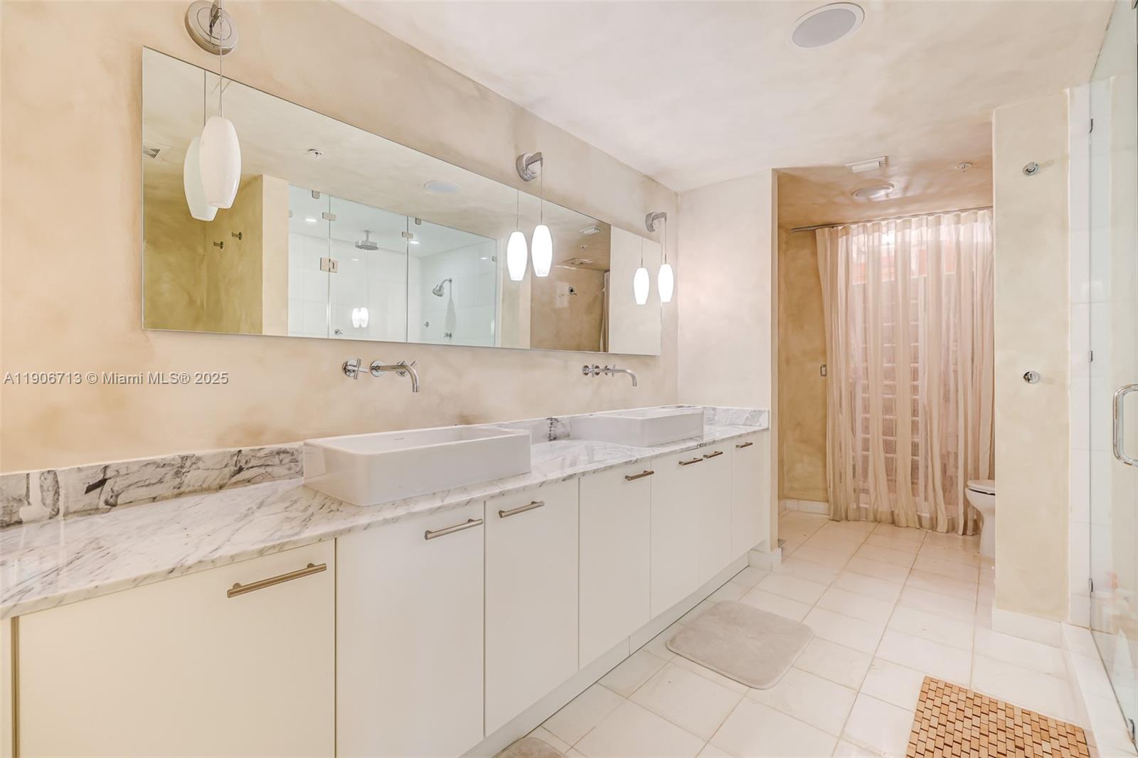 2001 Meridian Avenue, Unit 307 Miami Beach, FL 33139 - Photo 13 of 25 a spacious bathroom with a granite countertop sink and a mirror