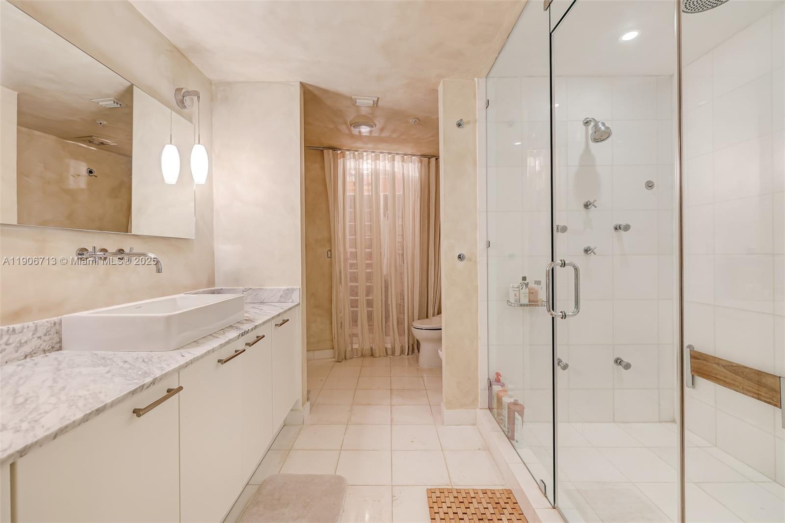 2001 Meridian Avenue, Unit 307 Miami Beach, FL 33139 - Photo 14 of 25 a spacious bathroom with a granite countertop sink mirror and shower