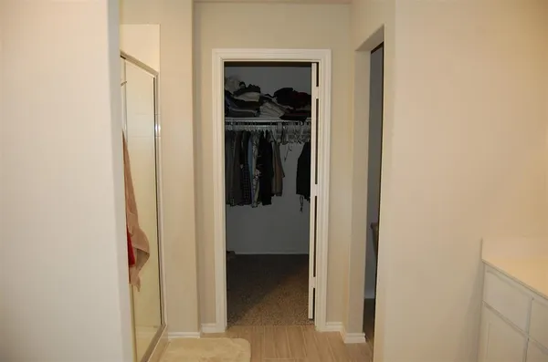 a view of walk in closet with clothes and shoes