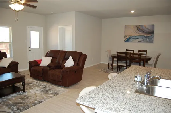a kitchen with stainless steel appliances granite countertop a sink a microwave and wooden cabinets