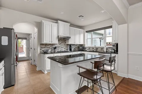 a kitchen with stainless steel appliances granite countertop a sink stove and cabinets