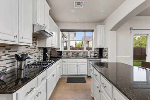 a kitchen with stainless steel appliances granite countertop a refrigerator stove and sink