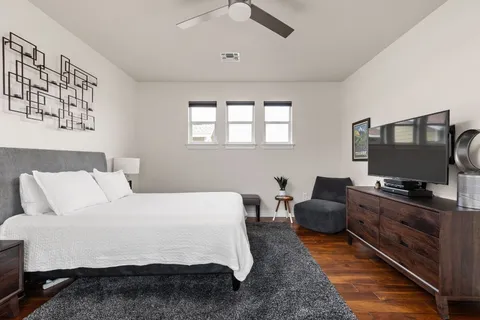 a bedroom with a bed and a dresser with mirror