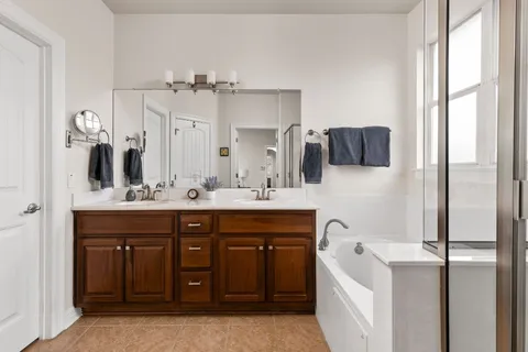 a bathroom with a tub sink and mirror