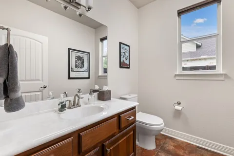 a bathroom with a toilet a sink and mirror