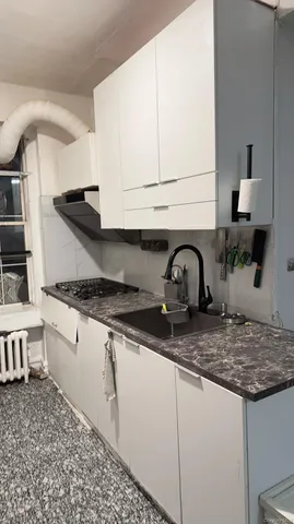 a kitchen with granite countertop a sink and cabinets