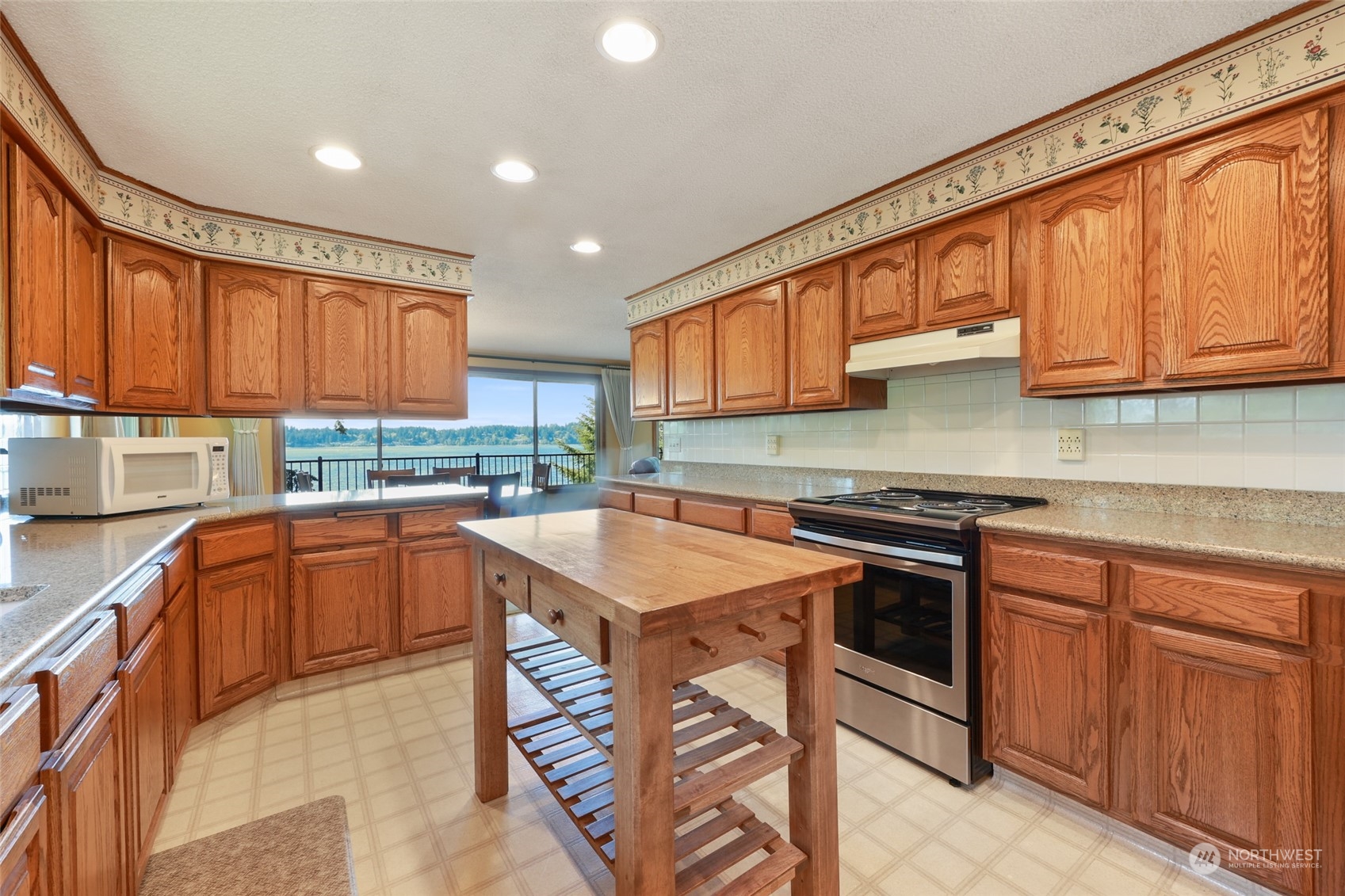 3545 Boston Harbor Road Northeast Olympia, WA 98506 - Photo 5 of 36 a kitchen with stainless steel appliances granite countertop a stove top oven a sink dishwasher and cabinets with wooden floor