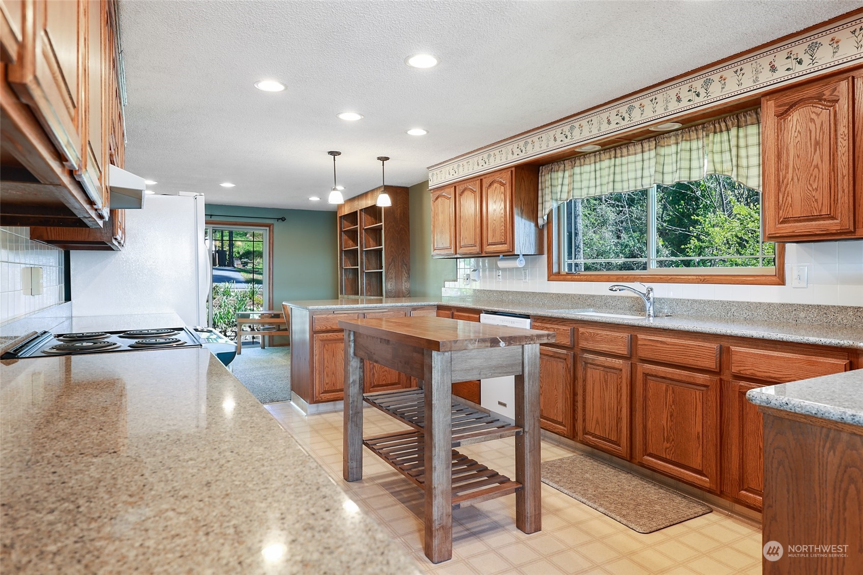 3545 Boston Harbor Road Northeast Olympia, WA 98506 - Photo 7 of 36 a kitchen with stainless steel appliances granite countertop sink stove and white cabinets with wooden floor