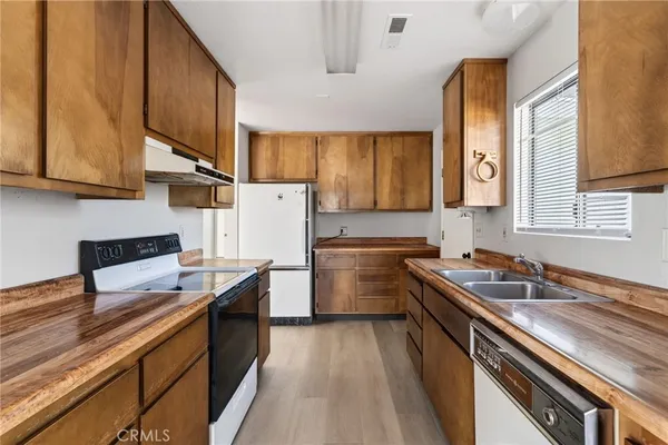 a kitchen with a sink stove top oven and cabinets