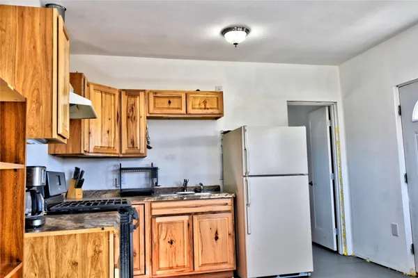 a kitchen with stainless steel appliances granite countertop a refrigerator a stove and a sink