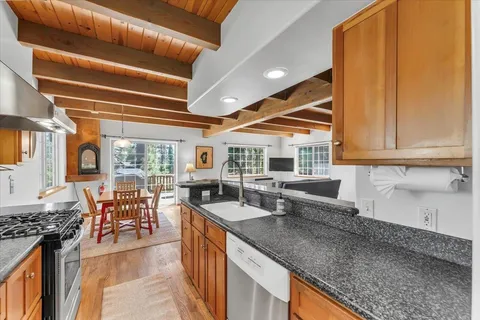 a kitchen with stainless steel appliances granite countertop sink stove and cabinets