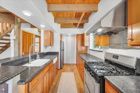 a kitchen with stainless steel appliances granite countertop a sink stove and cabinets
