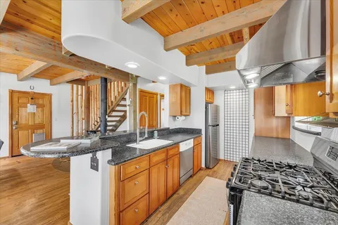 a kitchen with stainless steel appliances granite countertop a stove a sink and a refrigerator