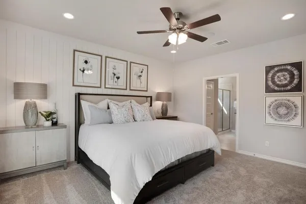a bedroom with a large bed and a chandelier