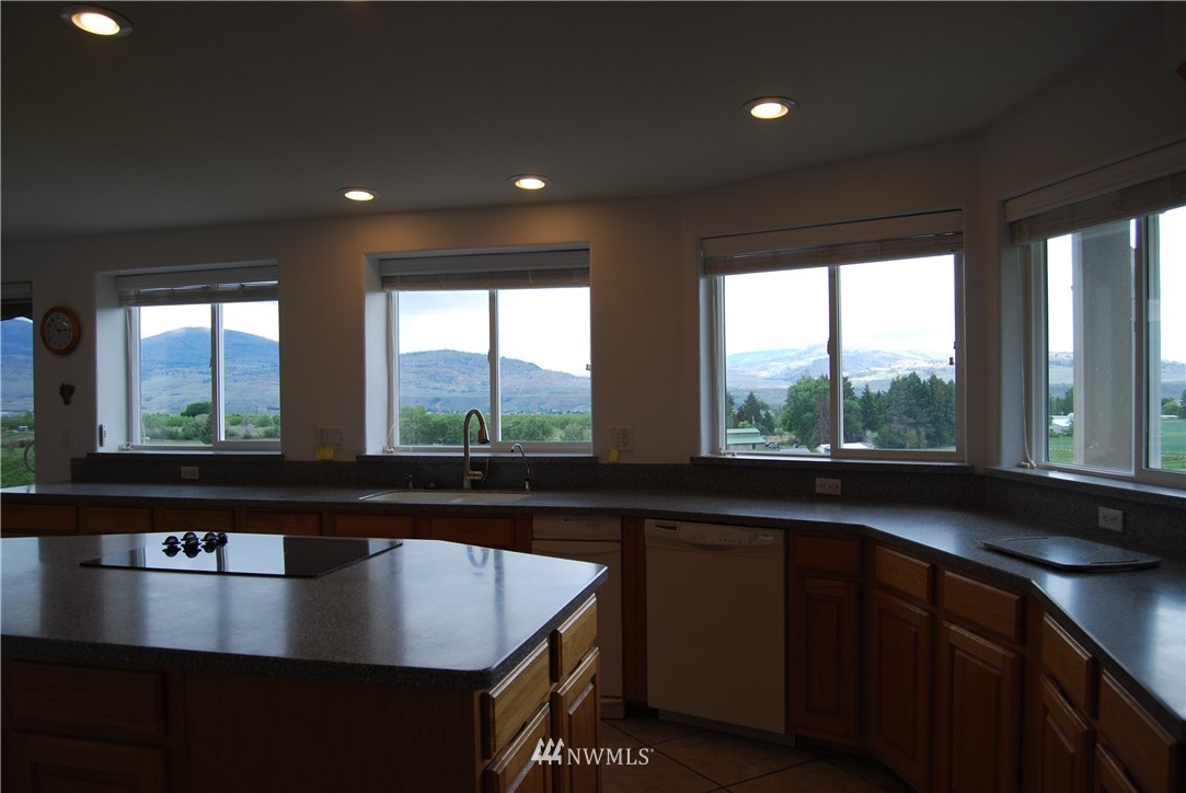 12 Caudill Road Omak, WA 98841 - Photo 25 of 37 a view of a kitchen with kitchen island a sink appliances and a large window