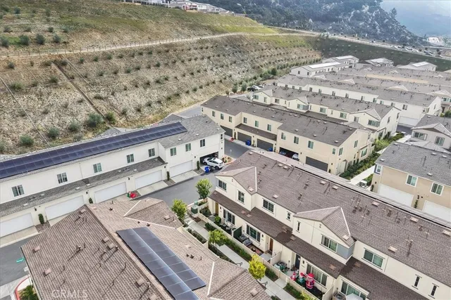 an aerial view of a house with pool lawn chairs and mountain view