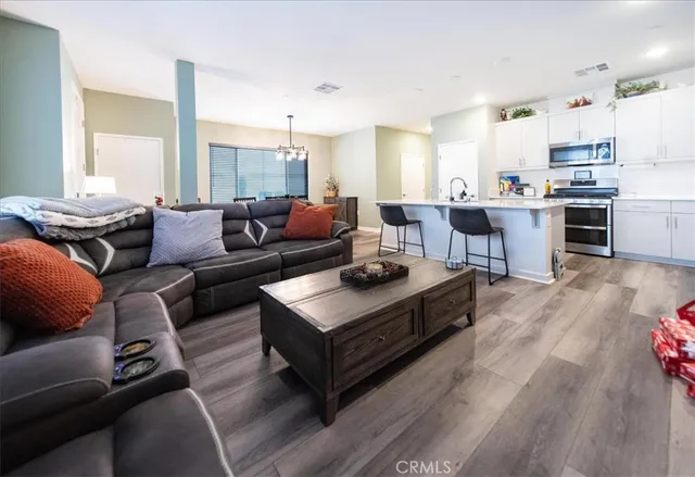 a kitchen with stainless steel appliances a table chairs and a refrigerator