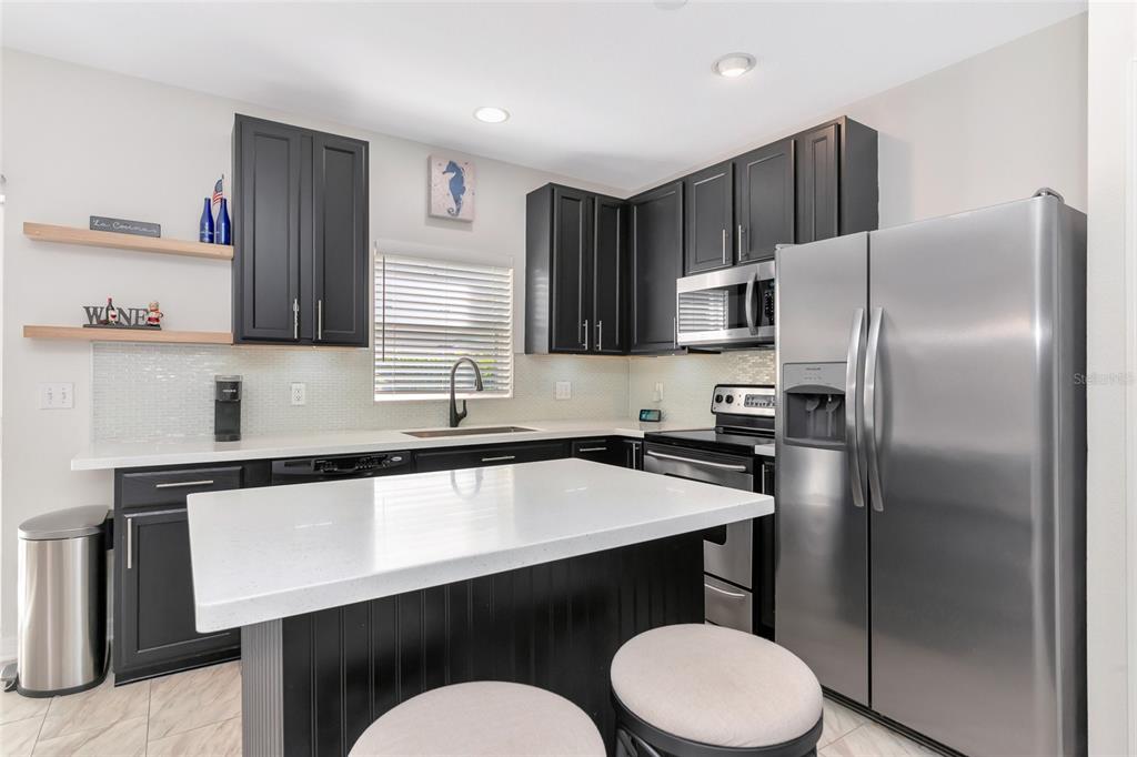 6205 Flagfish Court Lakewood Ranch, FL 34202 - Photo 13 of 67 a kitchen with a sink a refrigerator a stove a microwave and cabinets