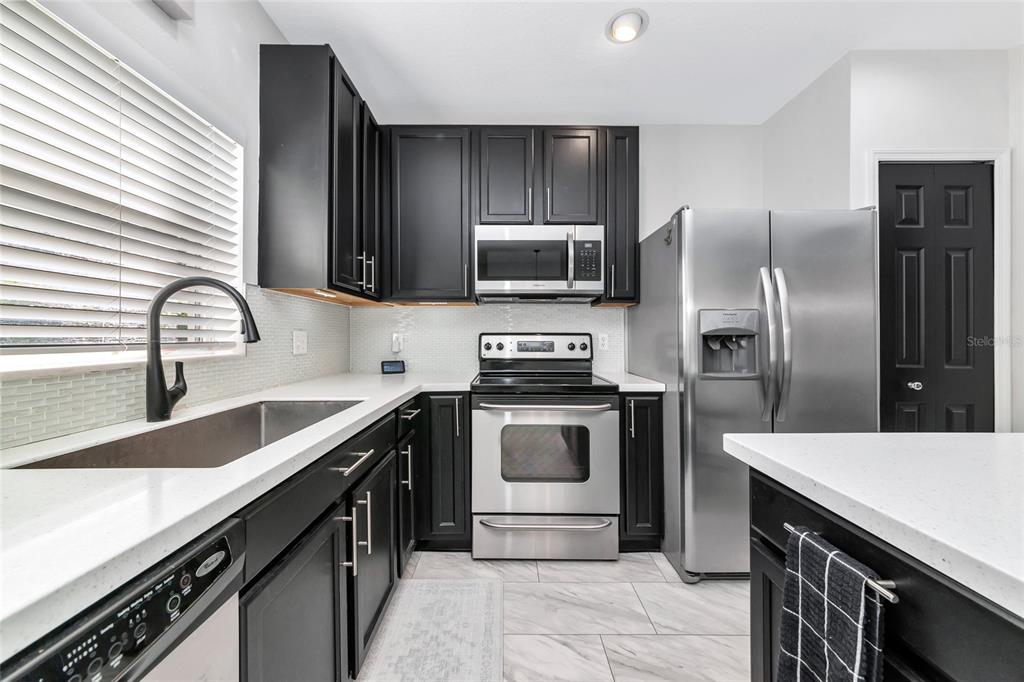6205 Flagfish Court Lakewood Ranch, FL 34202 - Photo 15 of 67 a kitchen with a sink stove and refrigerator
