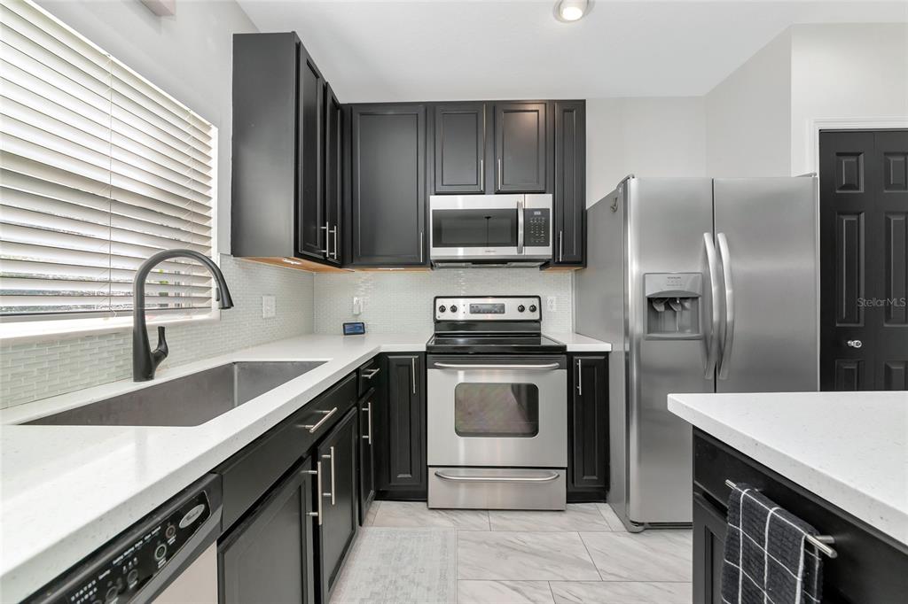 6205 Flagfish Court Lakewood Ranch, FL 34202 - Photo 16 of 67 a kitchen with a sink stove and refrigerator