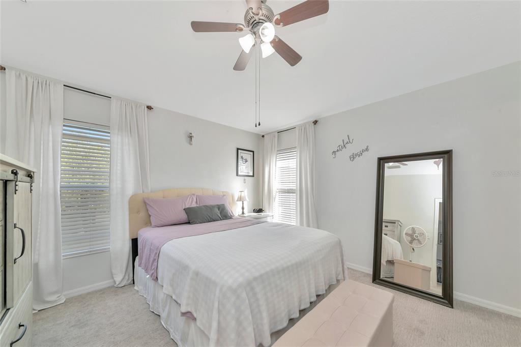 6205 Flagfish Court Lakewood Ranch, FL 34202 - Photo 22 of 67 a bedroom with a bed and a chandelier