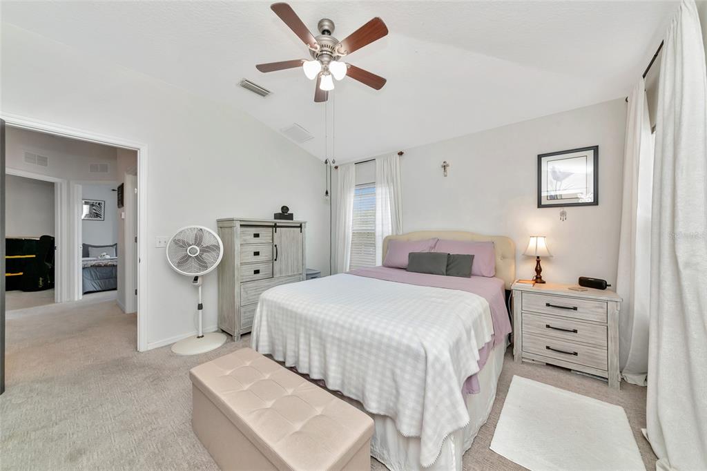 6205 Flagfish Court Lakewood Ranch, FL 34202 - Photo 24 of 67 a spacious bedroom with a bed and a chandelier
