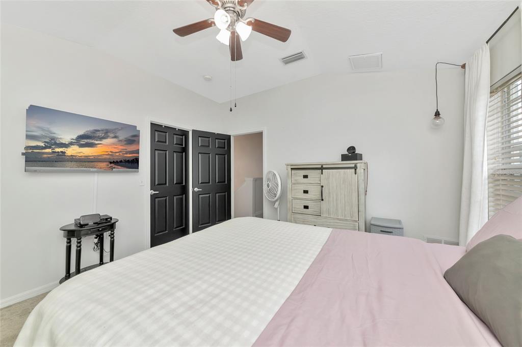 6205 Flagfish Court Lakewood Ranch, FL 34202 - Photo 26 of 67 a bedroom with a large bed and a chandelier