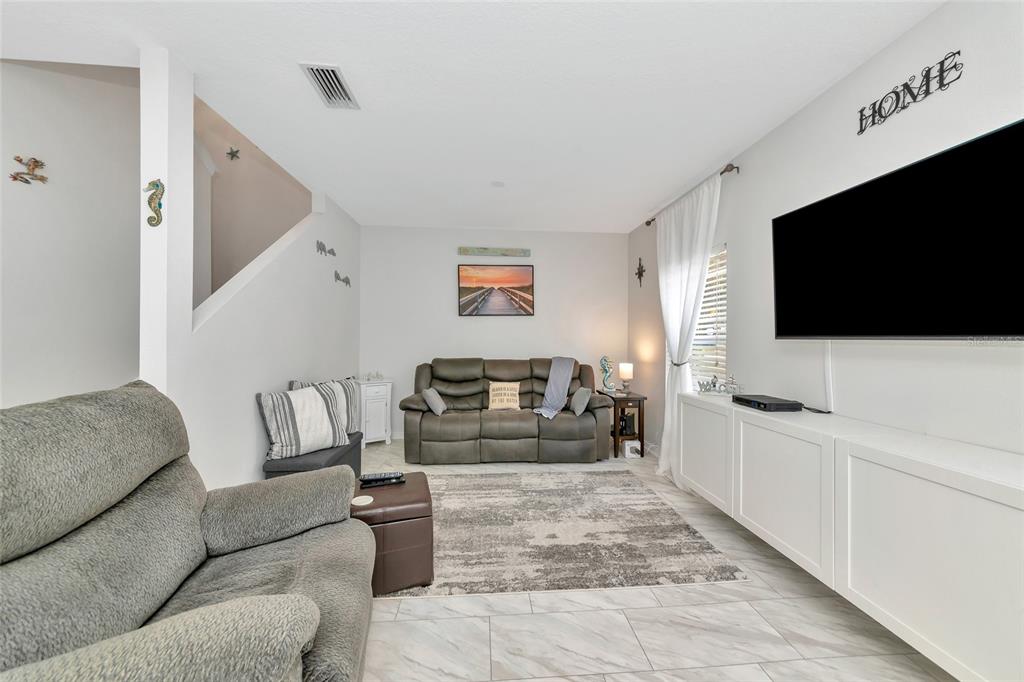 6205 Flagfish Court Lakewood Ranch, FL 34202 - Photo 5 of 67 a living room with furniture and a flat screen tv