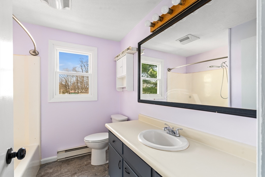 41 South Street, Unit 11 Easthampton, MA 01027 - Photo 20 of 30 a bathroom with a toilet a sink a mirror and a window