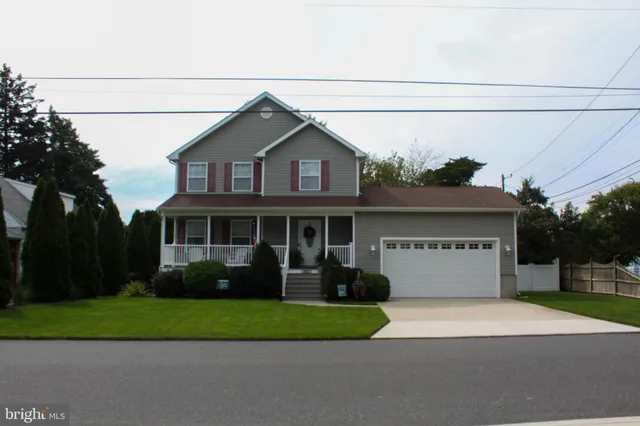 a front view of a house with a garden and plants