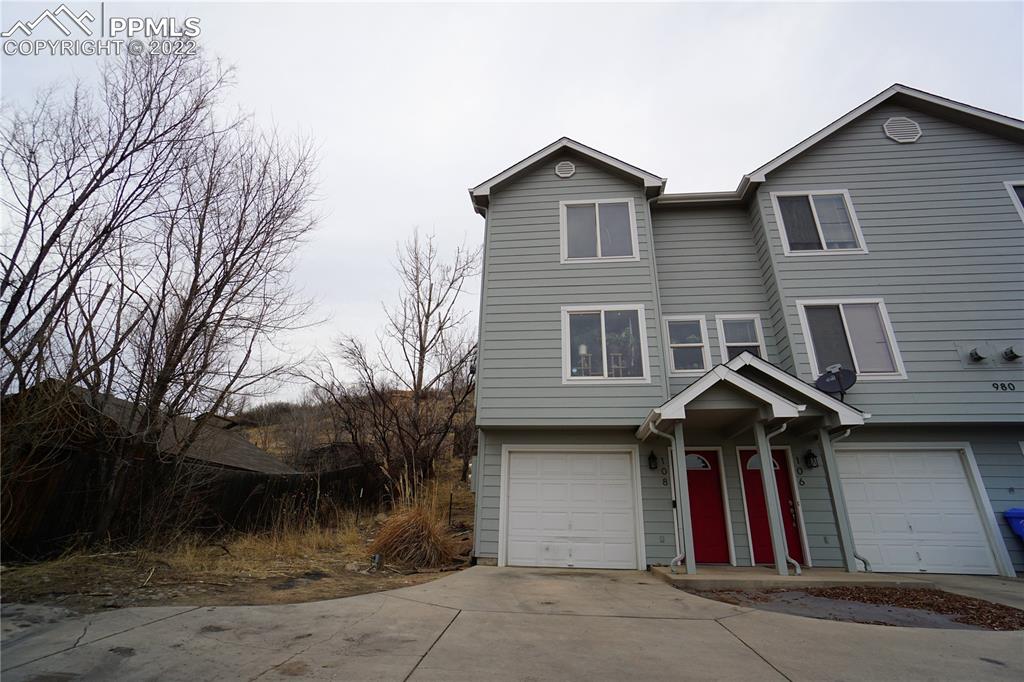 980 Mesa Valley Road, Unit 108 Colorado Springs, CO 80907 - Photo 1 of 21 a view of a house with a yard and large tree