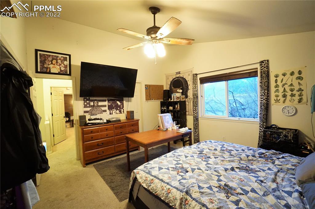 980 Mesa Valley Road, Unit 108 Colorado Springs, CO 80907 - Photo 12 of 21 a bedroom with a bed and a flat screen tv