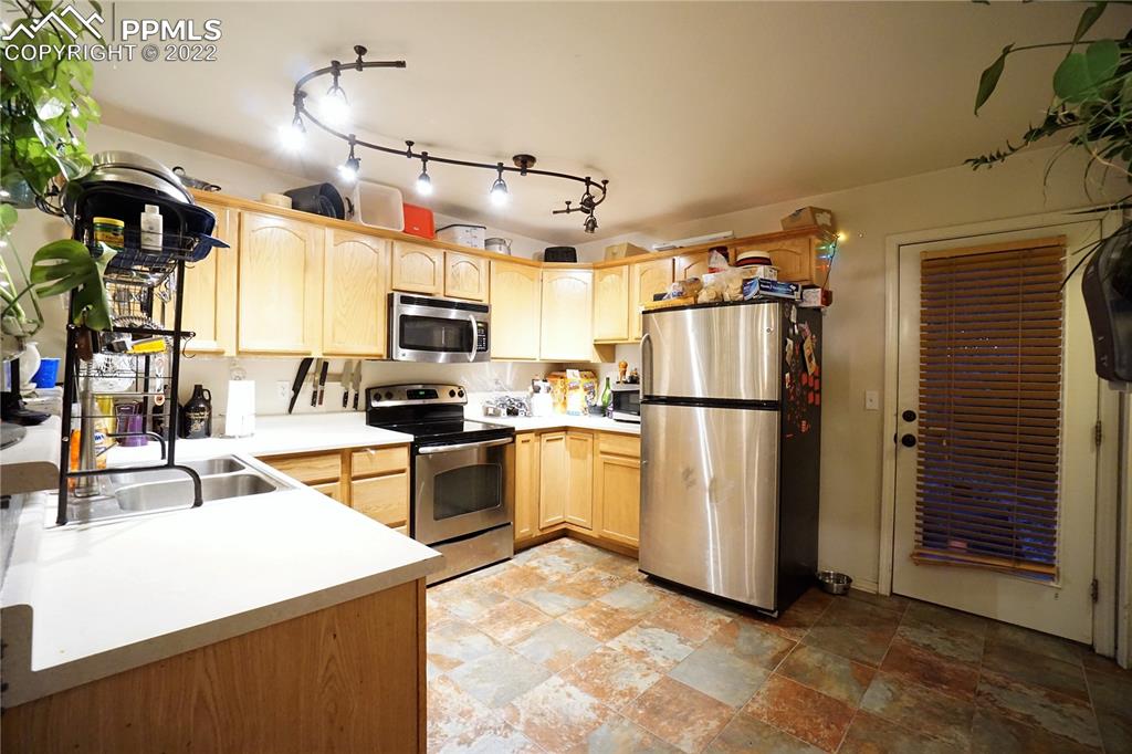 980 Mesa Valley Road, Unit 108 Colorado Springs, CO 80907 - Photo 7 of 21 a kitchen with refrigerator and microwave