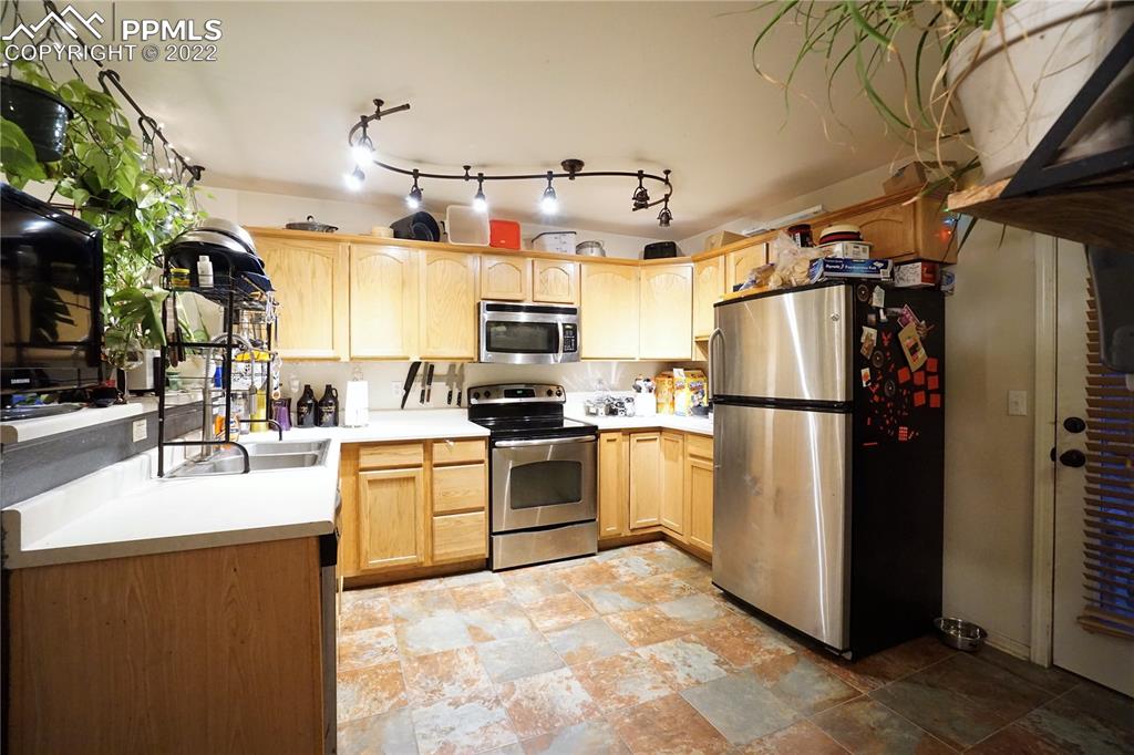 980 Mesa Valley Road, Unit 108 Colorado Springs, CO 80907 - Photo 8 of 21 a kitchen with cabinets a refrigerator and a stove